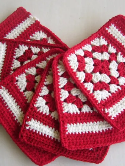 This stack of red and white granny square coasters shows the different variations I made. They are perfect for adding a festive touch to a table.