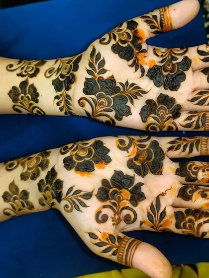 This design showcases the rich, dark stain of organic henna, with bold floral patterns on the back of the hands.