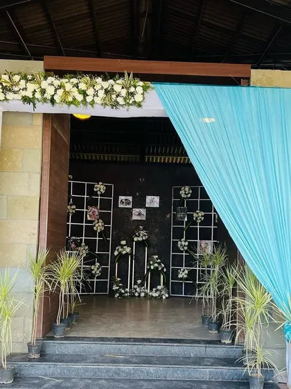We designed this beautiful entrance with floral arrangements and drapes, creating a welcoming passage that leads guests to the personalized photo gallery.