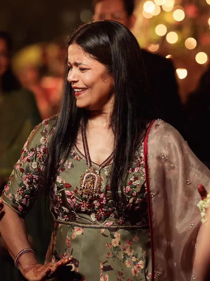 A candid moment of joy. This close-up shows the hand-highlighted floral print on the satin anarkali, detailed with french knots, beads, and katdana.