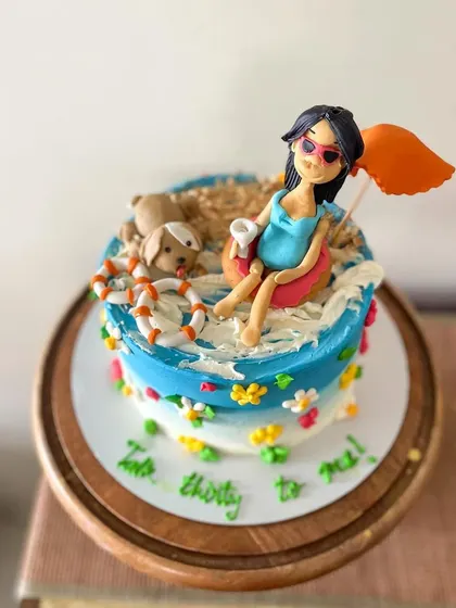 A close-up of the fondant figurine, complete with sunglasses and a drink.