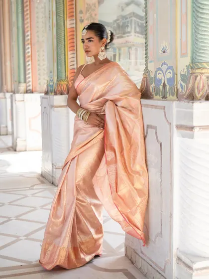 A full-length view of our classic baby pink silk saree. It's a perfect choice for a wedding guest who appreciates traditional elegance.