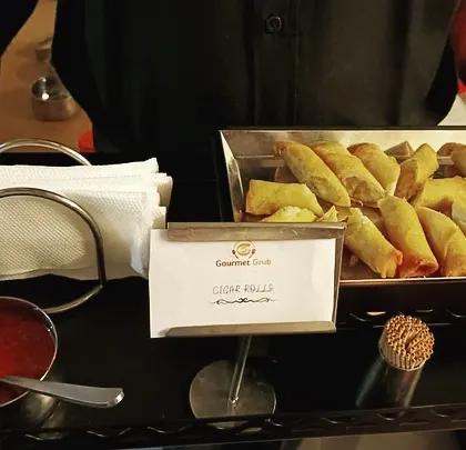 A tray of our crispy cigar rolls, ready to be served to guests at a birthday party.