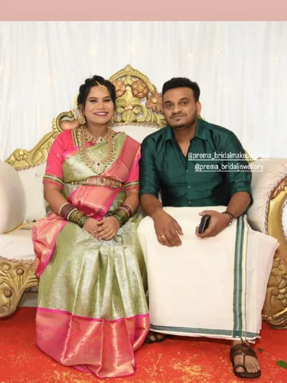 The couple seated, giving a full view of the jewellery and her beautiful silk sarees.