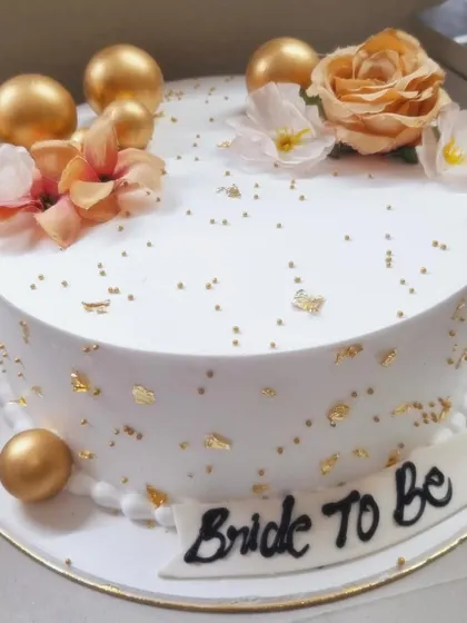 Another look at the sophisticated 'Bride to Be' cake, highlighting the shimmer of the gold details and the soft texture of the flowers.