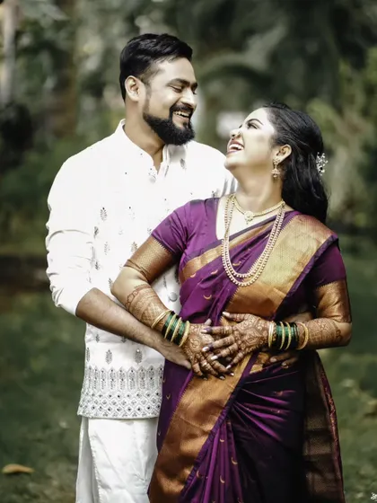 A joyful and candid portrait of the couple, sharing a laugh in a beautiful garden setting.