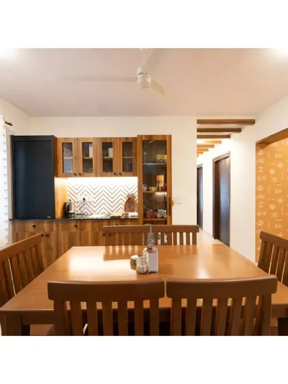 A full view of a dining room where our custom six-seater table and chairs are paired with a matching crockery unit. The warm wood tones and integrated lighting create a welcoming ambiance for dining and entertaining.