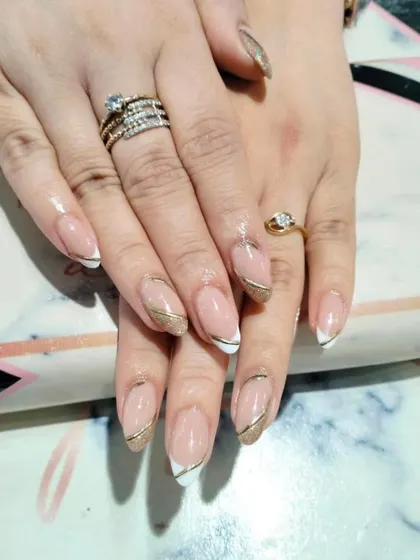 A sophisticated design featuring a classic white French tip elegantly separated by a clean, curved gold line.