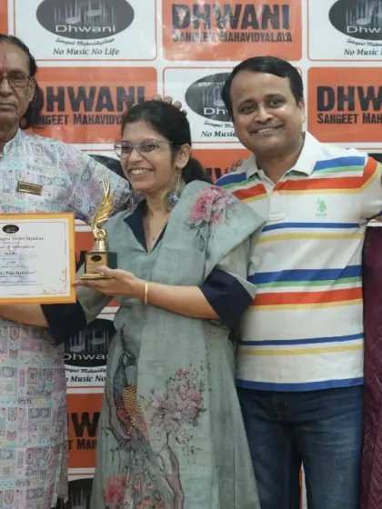 An adult student celebrates her musical achievement with her family and guru.