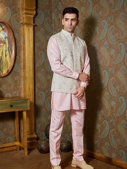 A light pink kurta paired with a taupe-colored bundi featuring fine floral embroidery. This is a charming and elegant choice for a day event or a destination wedding.