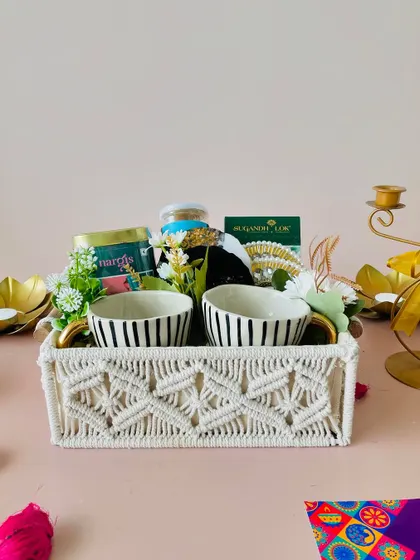 This premium macrame tray hamper includes two gold-handled ceramic cups, gold-infused coasters, and other luxury items for a truly special gift.