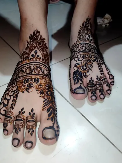 A beautiful and intricate design for the feet, perfect for any special occasion. The dark tips on the toes are a classic touch.