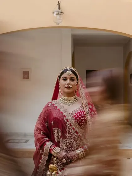 An artistic bridal portrait using motion blur, with the bride in sharp focus while her bridesmaids move around her, creating a dynamic effect.