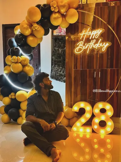 We love when our clients become like family. This photo captures the birthday boy posing with the stylish decor we created for his 28th birthday celebration at home.