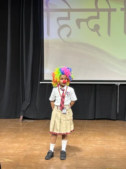 A student dressed as a clown performs on stage, bringing a fun and creative element to our Hindi Diwas celebration.