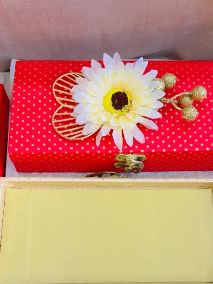 This red polka-dotted gift box with a white daisy is a cheerful and bright option for your festive gifts.