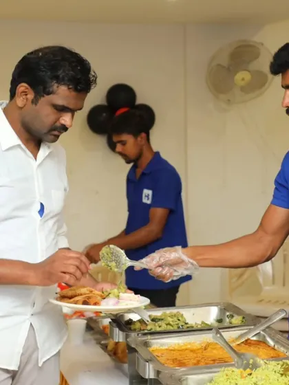 A server helps a guest with a serving of a vegetable dish, providing personalized attention even in a buffet setting.