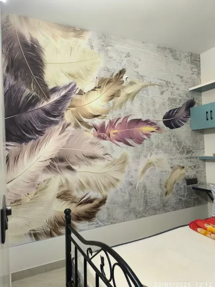 A soft and dreamy feather mural installed in a bedroom. The large, detailed feathers appear to float on the wall, creating a calm and restful atmosphere.