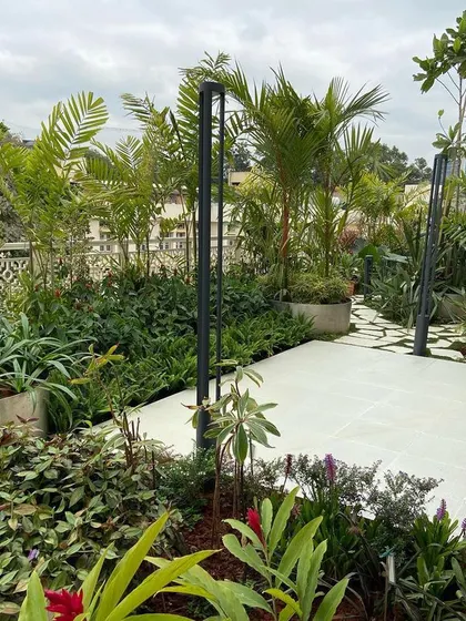 This view highlights the layered planting approach we use in our terrace garden designs. Taller palms and bamboo create a privacy screen while lower shrubs and ground cover fill out the space, creating a lush, multi-dimensional garden.