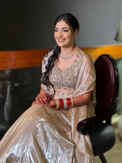 A happy, smiling bride ready for her reception. The soft glam makeup and elegant braided ponytail create a look that is both modern and timeless.