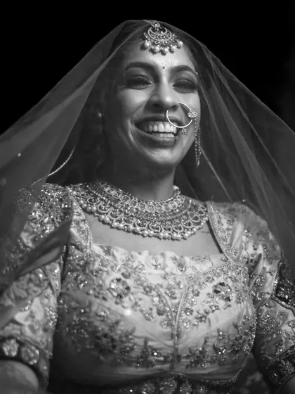 A candid black and white portrait of the bride, her face lit up with a huge, genuine smile. This shot is pure happiness.