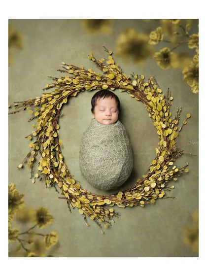 A peacefully sleeping newborn, swaddled snugly in a wreath of yellow flowers. This artistic composition highlights the delicate nature of your baby.