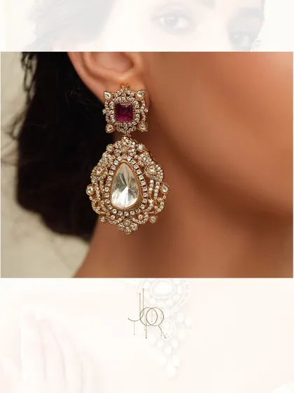 A magnificent pair of statement earrings, featuring a large uncut polki diamond and a ruby stud, surrounded by intricate diamond work.