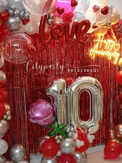 Another view of the 10th anniversary setup, showing the full balloon arch and the large silver '10' number balloons.