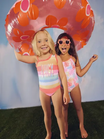 A playful shot for a kids' swimwear campaign. The bright colors, fun props, and excited expressions perfectly capture the feeling of a pool day.