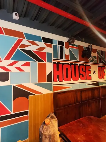 A closer view of the geometric mural, featuring bold colors, sharp lines, and the restaurant's name integrated into the design.