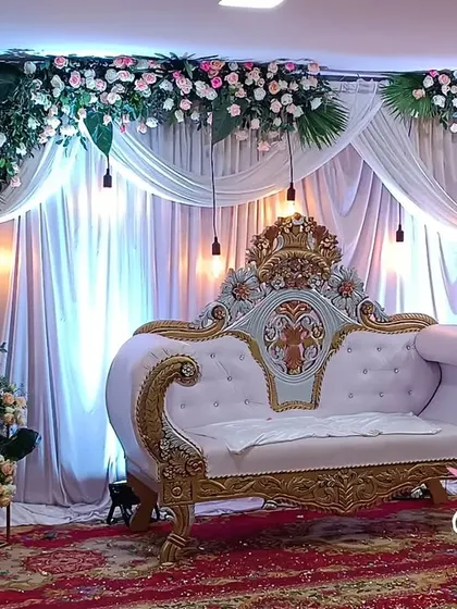 A classic stage setup with pink floral arrangements and elegant drapery. This versatile design is perfect for engagements, receptions, or anniversary celebrations, offering a timeless look.