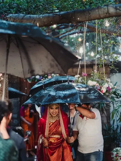 Monsoon weddings have a magic of their own. When it started to rain during Roshini's bridal entry, we were ready with umbrellas, and her smile lit up the entire venue, turning an unexpected moment into a beautiful memory.