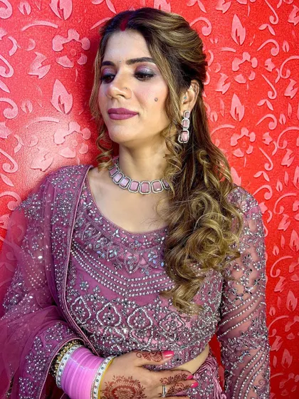 A side profile showcasing the elegant hairstyle and the detailed work on the sleeves of the magenta lehenga.