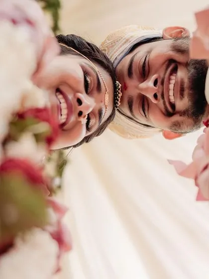 A beautiful, low-angle shot capturing the happy smiles of the bride and groom. This unique perspective highlights their connection and the joy of the moment.