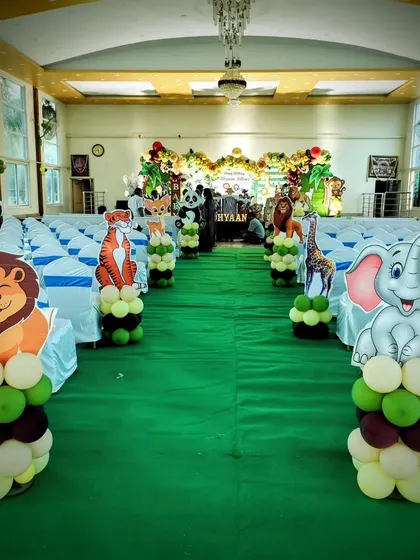 The entrance aisle for a jungle themed party, lined with animal-topped balloon pillars.