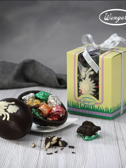 A hollow chocolate Easter egg broken open to reveal a surprise of smaller assorted chocolates inside. It's a gift within a gift.