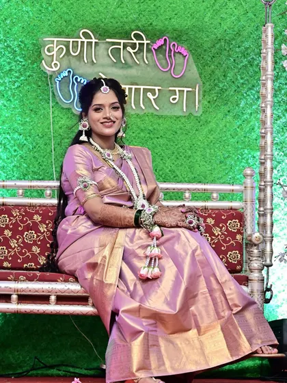 Another beautiful shot of the client on the ceremonial swing. The lighting highlights the shimmer of her saree and the flawless finish of her makeup, ensuring she looks stunning throughout the event.