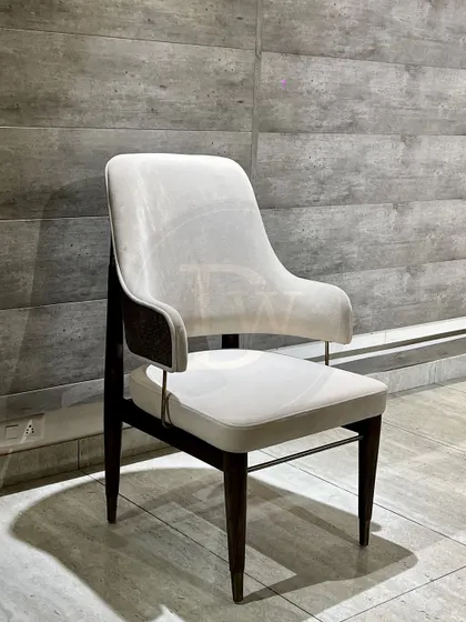 This dining chair combines a classic wooden frame with modern upholstery. The off-white fabric and dark wood create a timeless contrast, perfect for an elegant dining space.