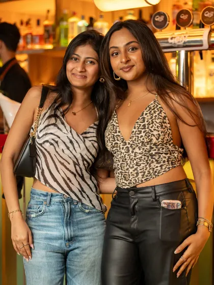 Two friends in stylish animal prints, posing for a photo before hitting the dance floor at Monkey Bar.