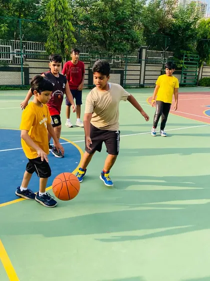 A junior player works on his dribbling technique with close supervision.