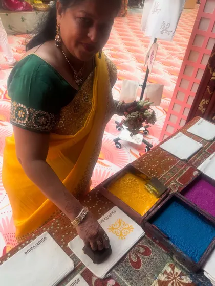 A guest fully engaged in printing her custom pouch at the Birla and Gokuldas Haldi party. We provide a rainbow of skin-safe, organic ink colors for everyone to choose from.