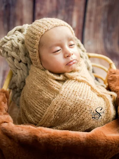 A closer view of the sleeping baby in the beige knit wrap, highlighting their peaceful face and tiny features.
