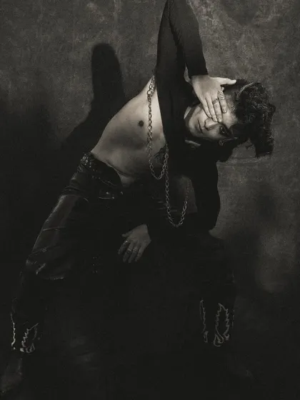 A dynamic and expressive pose from a dark, moody series. The black and white treatment emphasizes form and emotion.