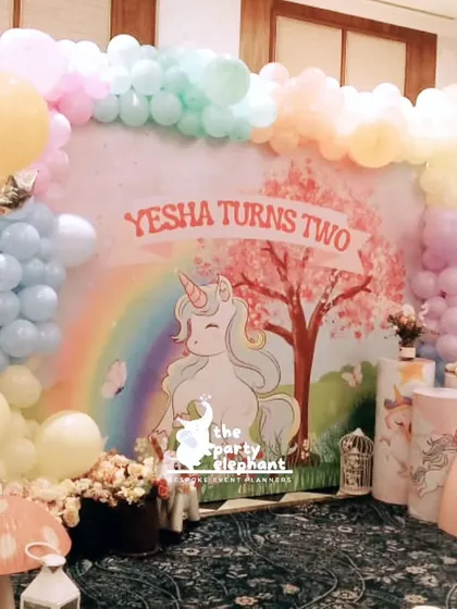 A different angle of the main unicorn backdrop, highlighting the layered balloon decor and whimsical props like the mushroom stool and lanterns.