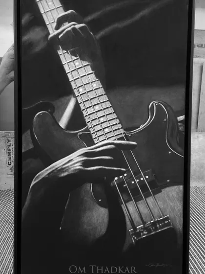 A 2 by 3 foot charcoal on linen artwork of a musician playing the bass guitar. The piece focuses on the hands and the instrument, capturing the passion of the performance.