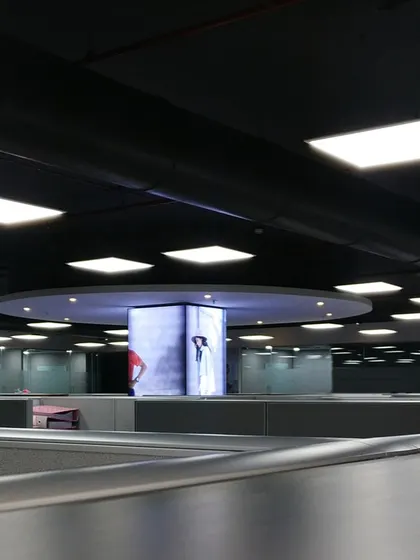 This perspective across the Skechers office cubicles shows the thoughtful lighting design. The large circular fixture complements the central display column, creating a cohesive and well-lit workspace.