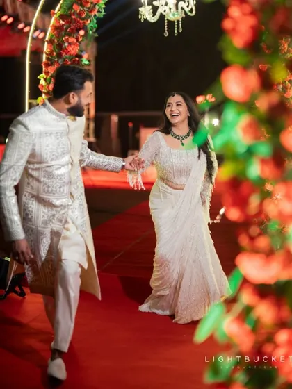 The couple making their entrance, hand-in-hand, with big smiles on their faces.