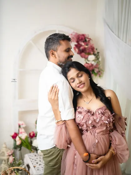 A peaceful and intimate embrace. The mother-to-be rests her head on her partner's shoulder, a simple gesture that speaks volumes of their connection.