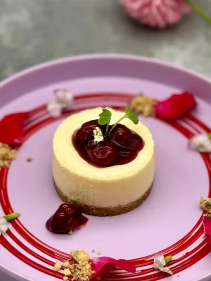 An exquisite plating of our Baked Cherry Cheesecake. Adorned with edible gold leaf and microgreens, this dessert is elevated to a fine-dining experience.