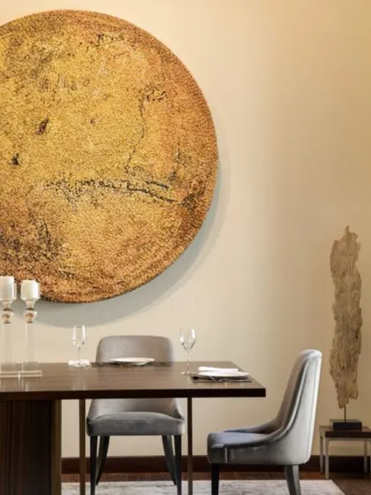 A close-up of the dining area in the Vasant Vihar home, highlighting the large circular artwork that anchors the space.